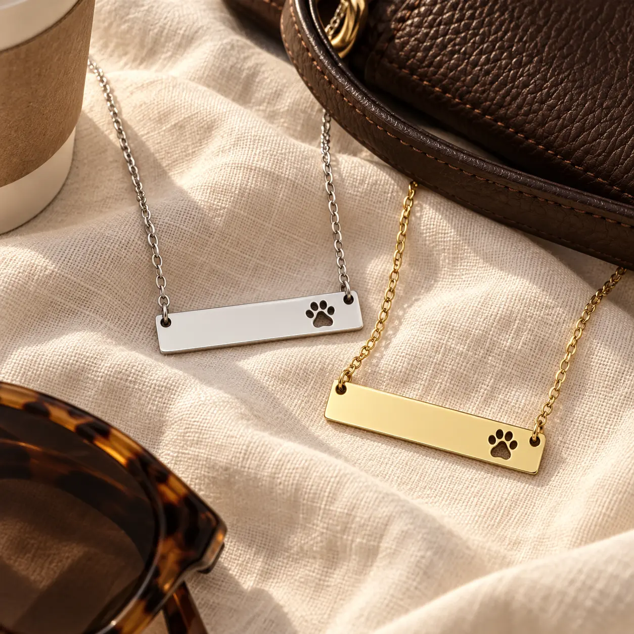 Gold and silver Paw Print Bar Necklaces with fixed paw-print cutouts displayed together
