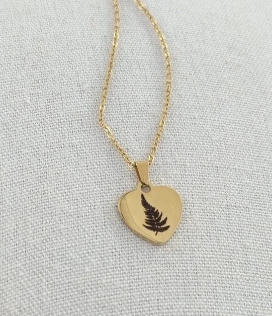 Gold heart necklace engraved with a delicate fern