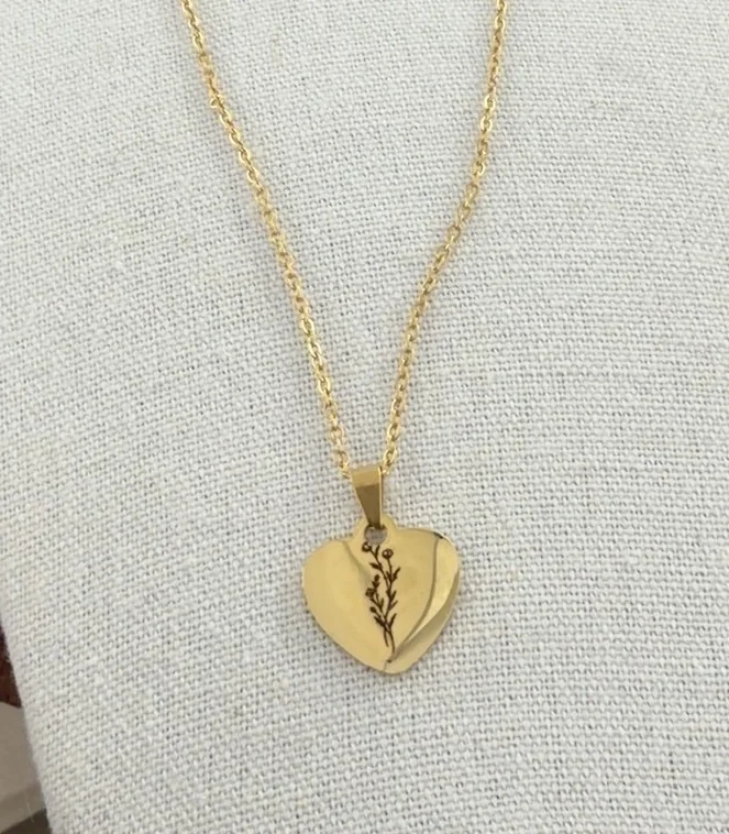 Gold heart necklace engraved with a delicate floral stem