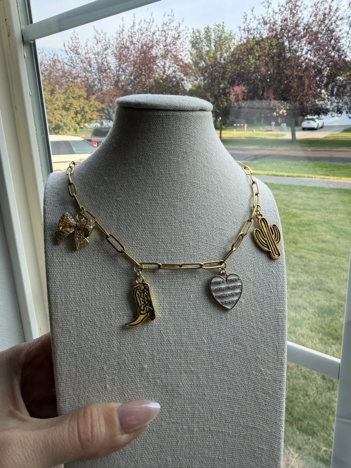 Custom gold western charm necklace on a jewelry display