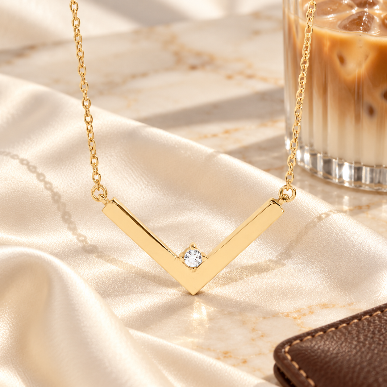 Gold Crystal Chevron Necklace with a center crystal displayed on ivory satin